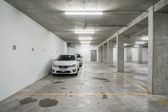 Intérieur d'un garage souterrain urbain avec places de parking bétonnées et marquages au sol jaunes