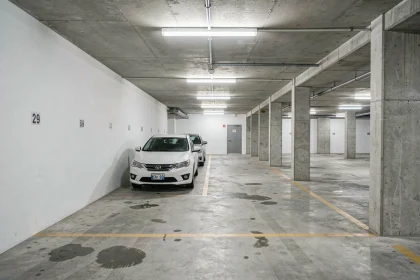 Intérieur d'un garage souterrain urbain avec places de parking bétonnées et marquages au sol jaunes